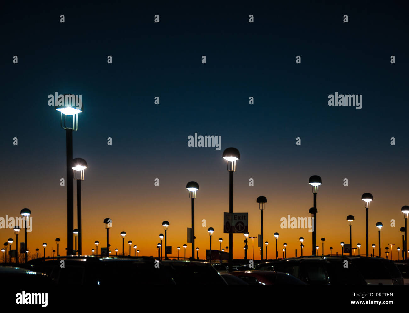 La lueur orange brillante du crépuscule peint le ciel du soir au-dessus du pont de stationnement à l'aéroport international d'Atlanta. (ÉTATS-UNIS) Banque D'Images