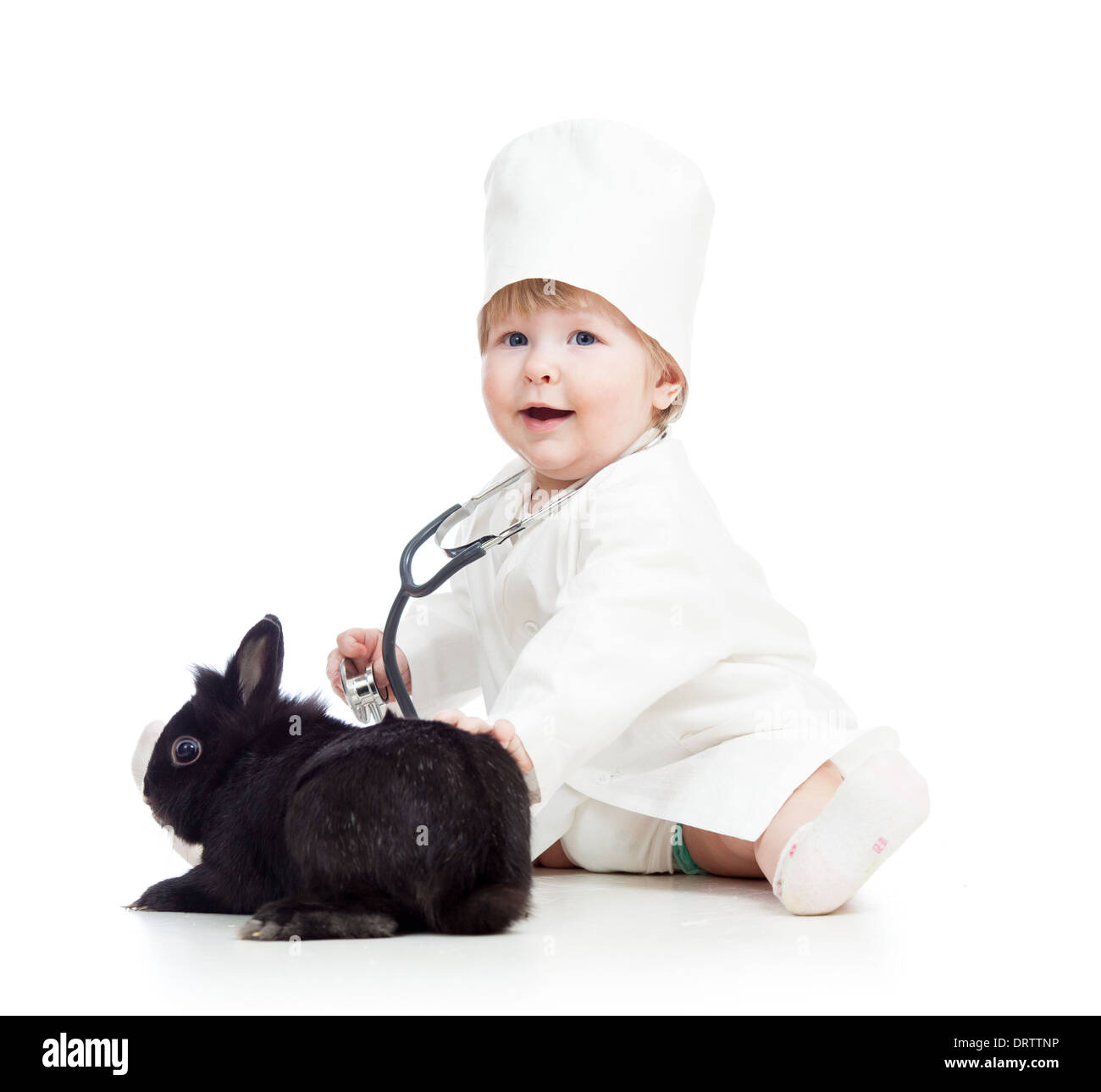 Avec des vêtements pour enfants de médecin jouant avec bunny pet Banque D'Images