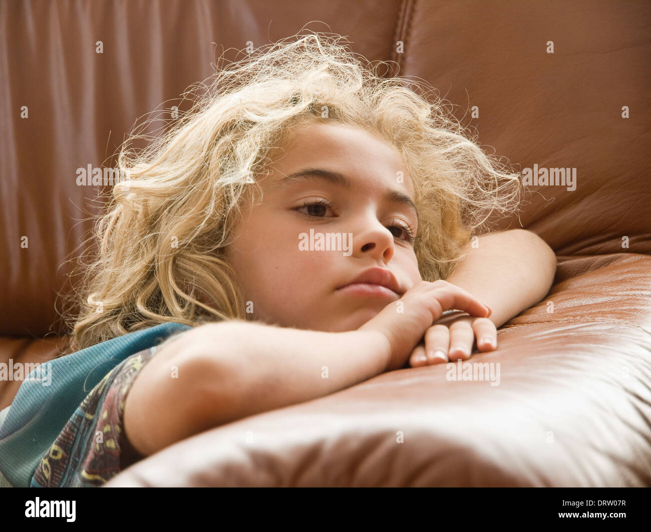 Petite fille à regarder la télévision. La jeune fille est couchée et se concentrer. Banque D'Images