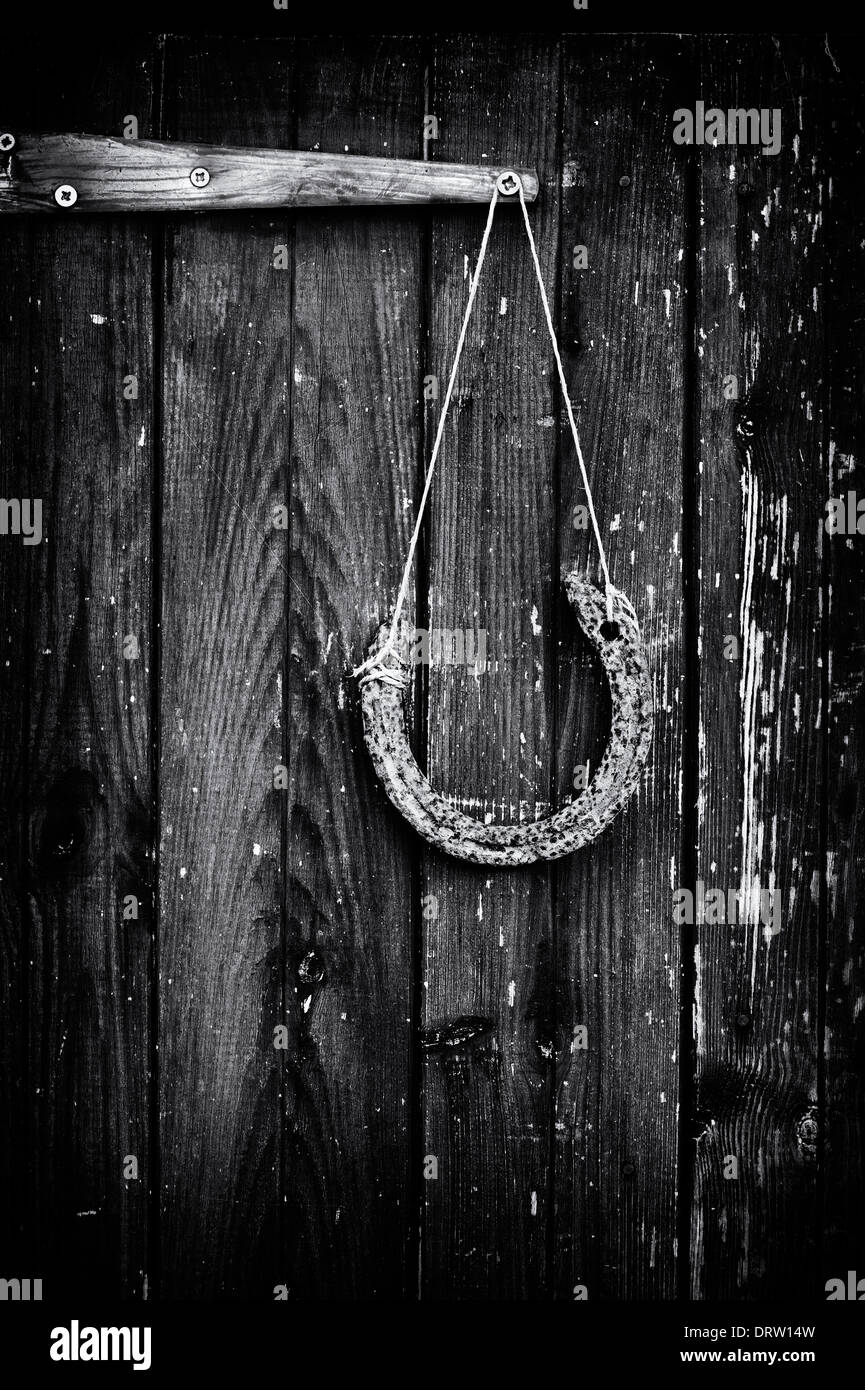 Horse Shoe accroché sur une ancienne porte de l'habitacle. Le noir et blanc Banque D'Images