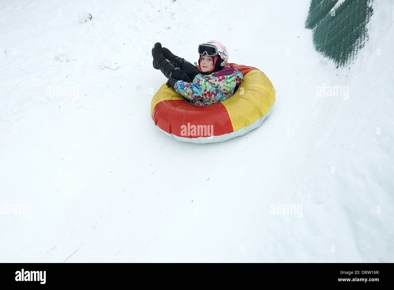 Jeune enfant girl enjoying snow tubing Banque D'Images