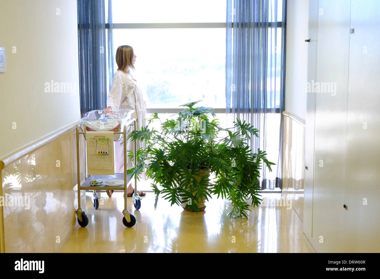 Une femme en chemise d'hôpital avec son nouveau-né à la maternité après l'accouchement Banque D'Images