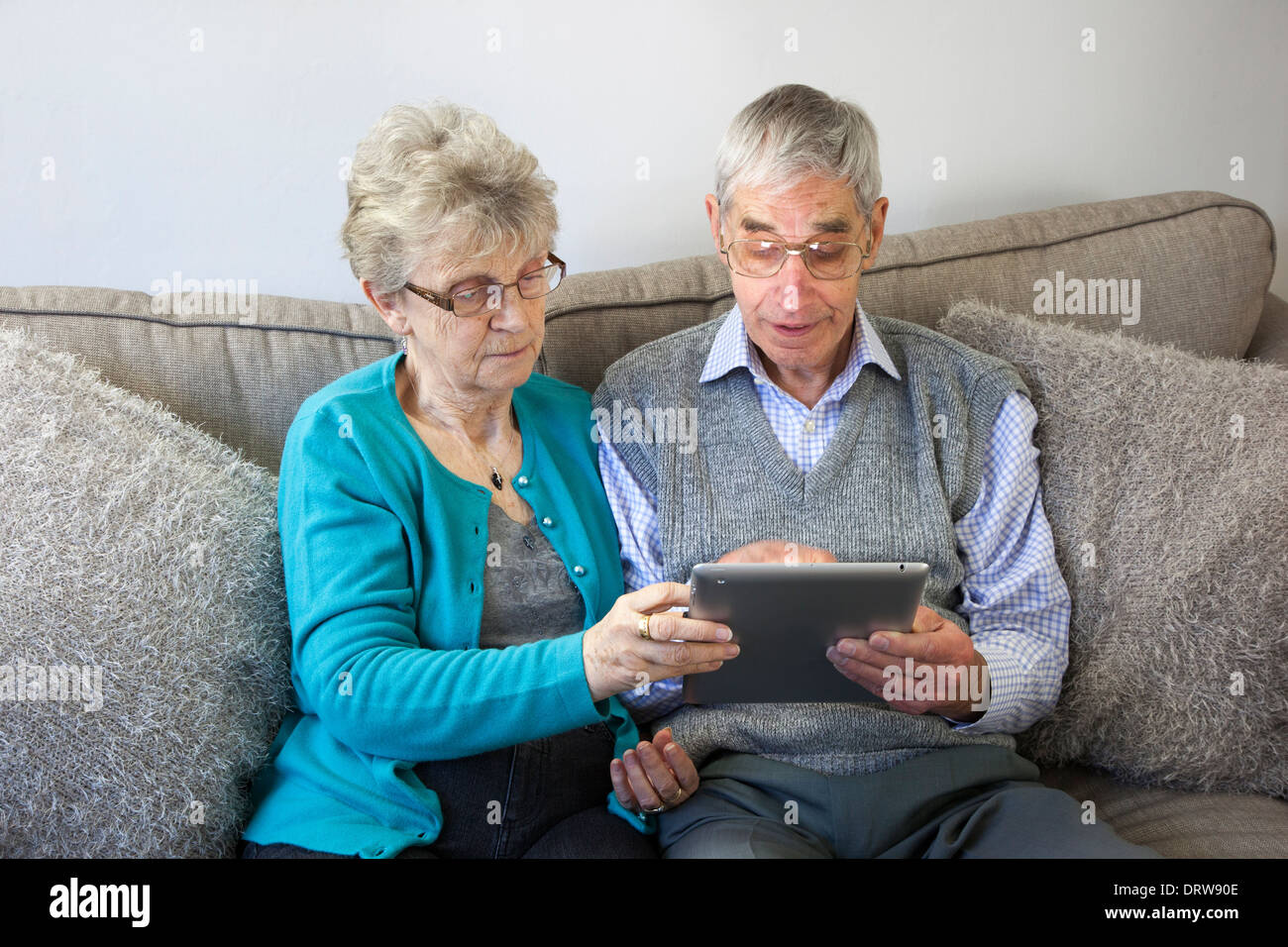 Couple à l'aide d'une tablette numérique à la maison. Banque D'Images