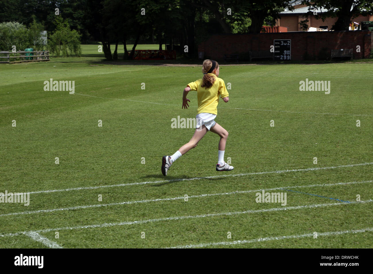 Jeune fille courir sur la voie en T-shirt, short et des formateurs l'Angleterre Banque D'Images