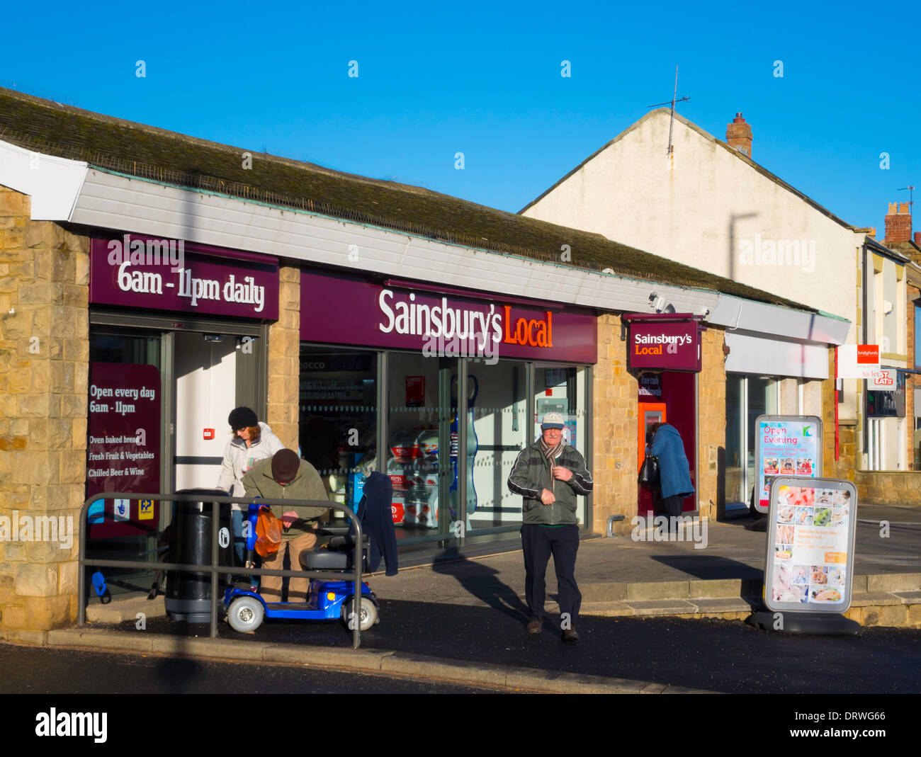 Personnes âgées à l'extérieur d'un village shopping supermarché Sainsbury's convenience store Banque D'Images