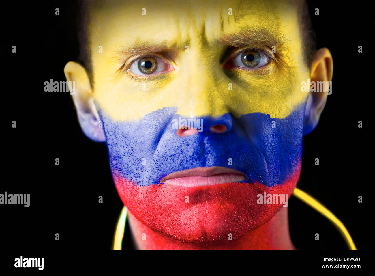 Fan de football agressifs avec leur visage peint avec le drapeau colombien. Banque D'Images