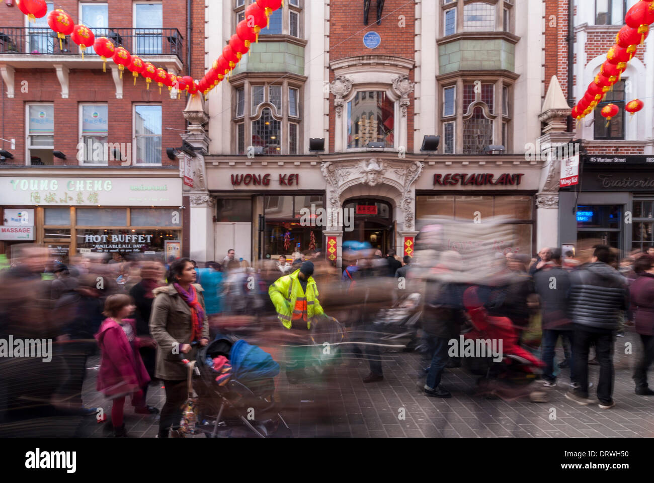 Chinatown, Londres, Royaume-Uni. 2 février 2014. Un homme recueille des foules comme litière passe devant lui par dans le quartier chinois alors qu'ils célèbrent l'année du cheval Banque D'Images