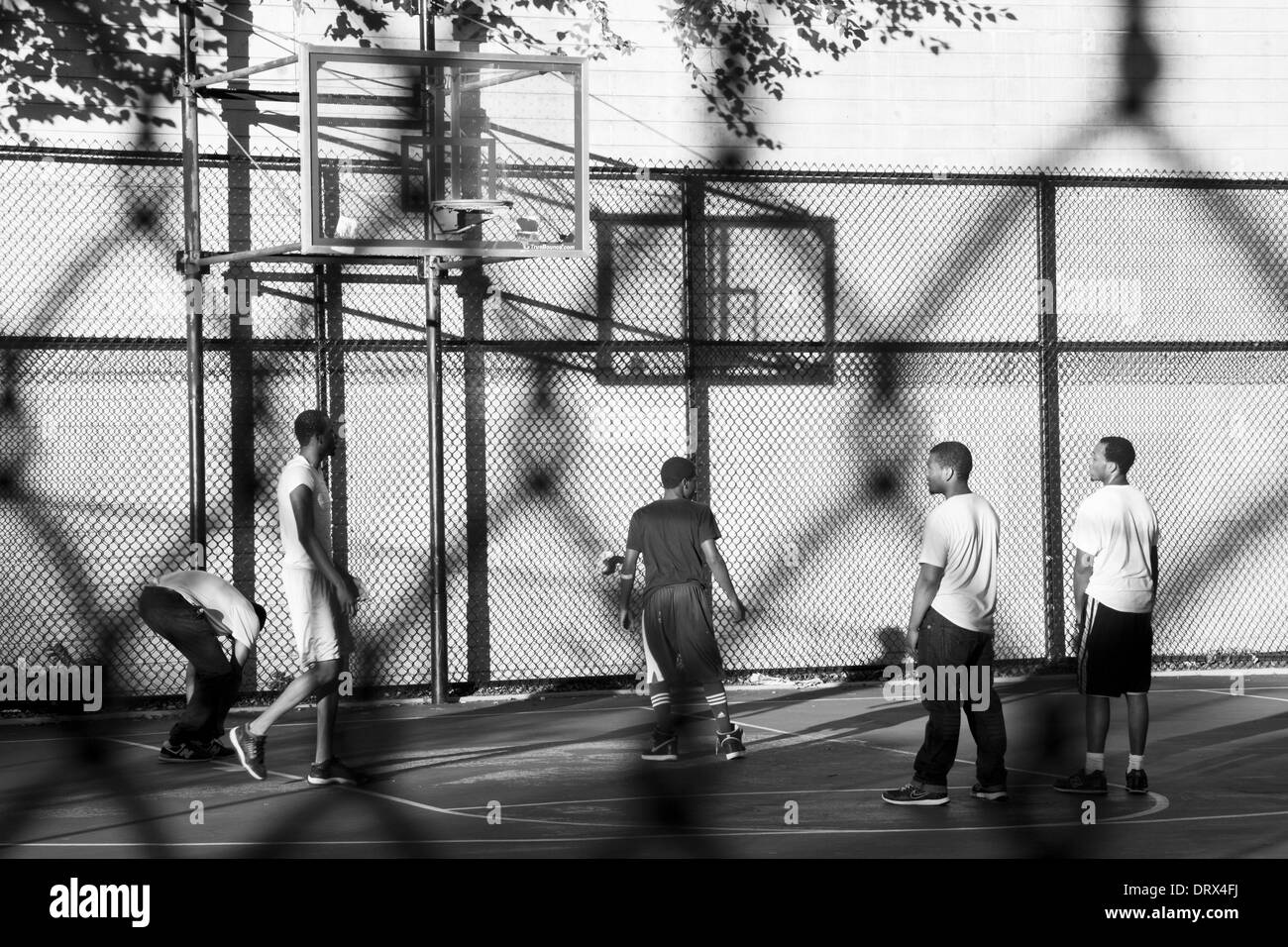 Image prise dans la clôture d'hommes jouant au basket-ball à New York. Banque D'Images