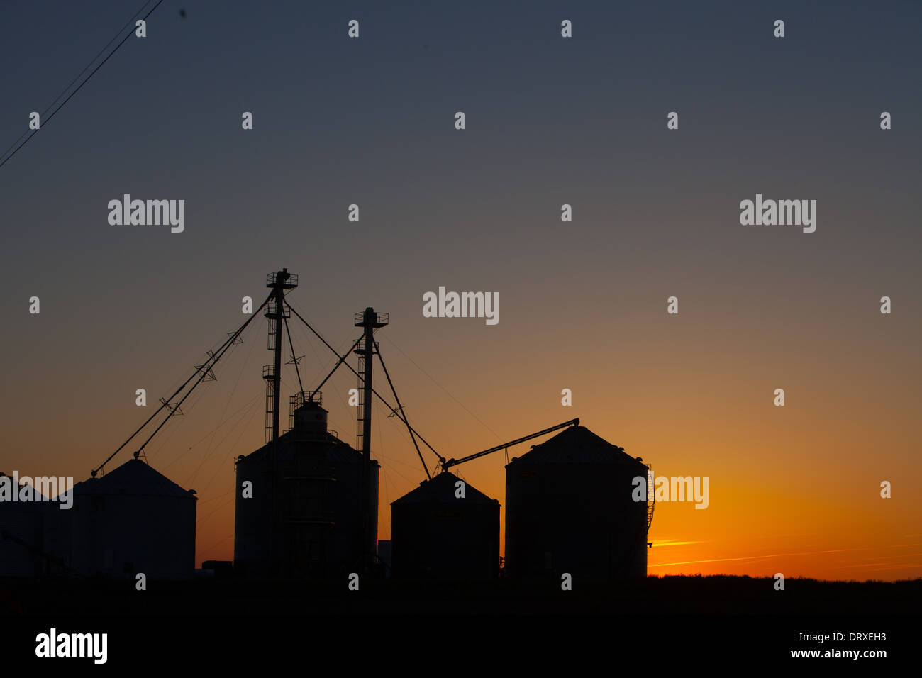 L'élévateur à grain du midwest au coucher du soleil sur les plaines de l'Illinois. Banque D'Images