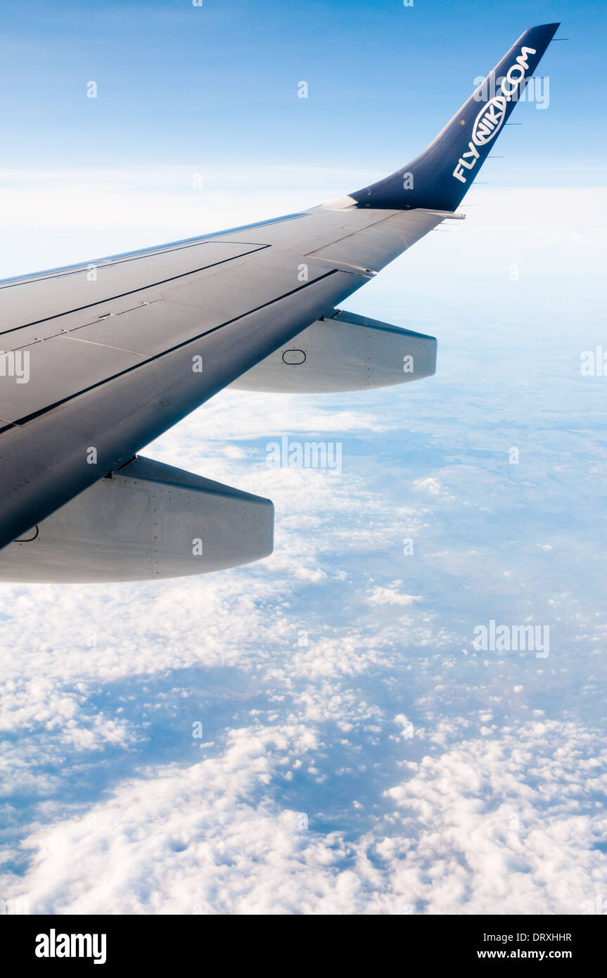 Tourné à partir de la fenêtre de l'avion, montrant flyniki.com logo sur aile d'avion, avec blue cloudy sky over Earth Banque D'Images