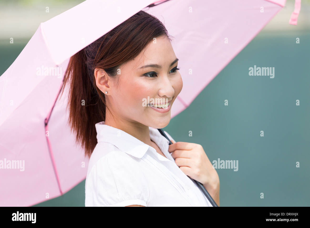 Young Asian business woman holding an umbrella de plein air Banque D'Images