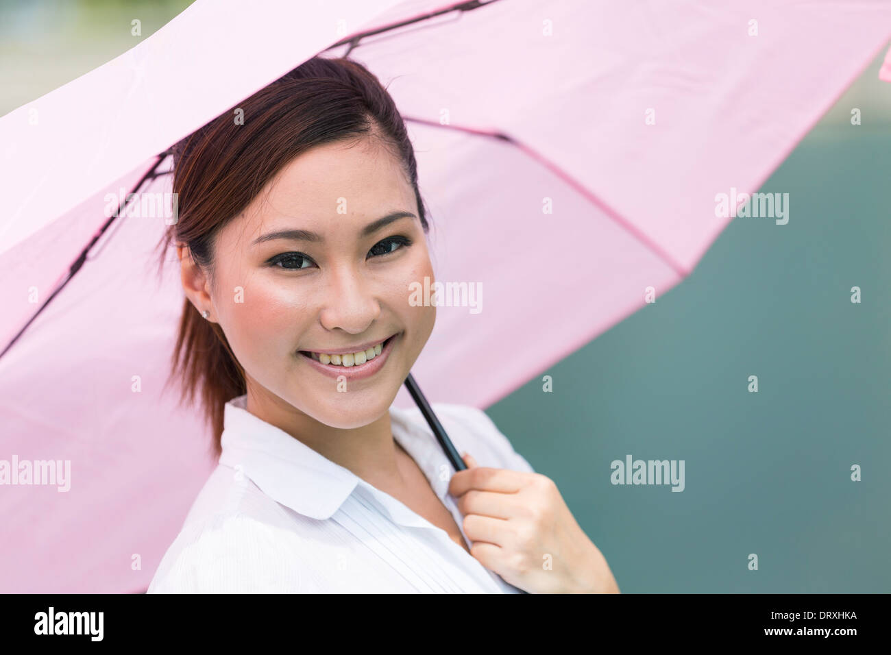 Young Asian business woman holding an umbrella de plein air Banque D'Images