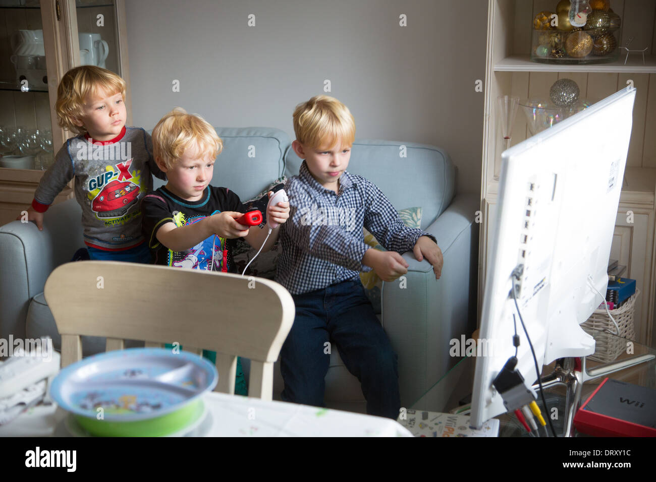 Trois jeunes Frères jouant un jeu Wii Photo Stock - Alamy