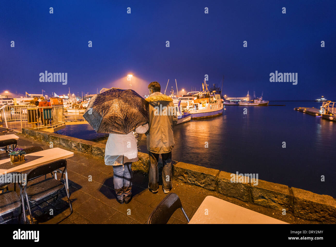 Couple dans la pluie par port de Reykjavik, Reykjavik, Islande Banque D'Images