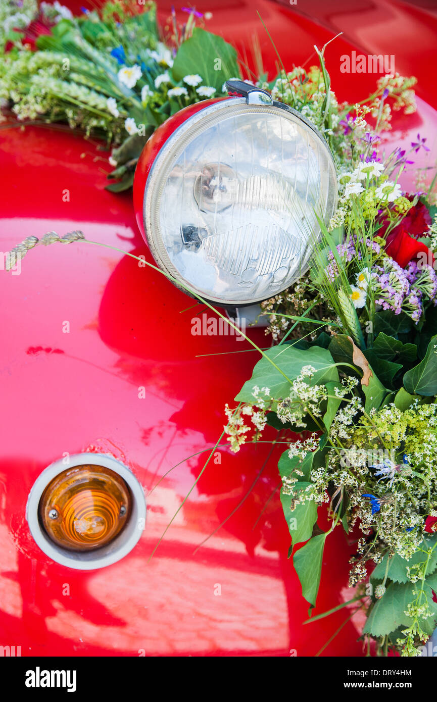 Lampe d'une voiture de mariage rouge avec bouquet de fleurs Banque D'Images