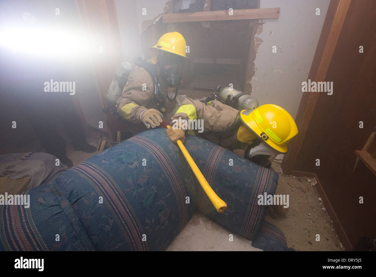 Les étudiants de l'école secondaire académie du feu ramper dans la maison remplie de fumée à piégé des occupants 'lors d'un exercice d'entraînement Banque D'Images