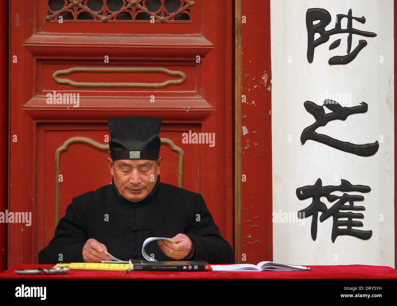 Beijing, Chine, Chine. Jan 31, 2014. Un moine taoïste inspecte les billets comme lumière chinois d'encens et prier à la Dongyue temple Taoïste le premier jour de la nouvelle année lunaire de la Chine à Beijing le 31 janvier 2014. Selon le calendrier lunaire chinois, la Chine se félicite de l'année du cheval le 31 janvier. Le cheval, classé septième parmi les 12 animaux sur le zodiaque chinois, est l'un des signes les plus aimés comme il est largement considéré comme un symbole de la force et de la vitesse. © Stephen Shaver/ZUMAPRESS.com/Alamy Live News Banque D'Images