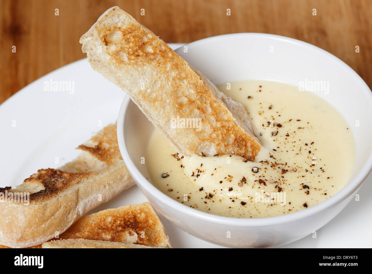 Faites trempette au fromage, fromage doux, de lait, d'oeufs et le beurre dans un bain-marie, saupoudrée de poivre servi avec ciabata crostini. Banque D'Images