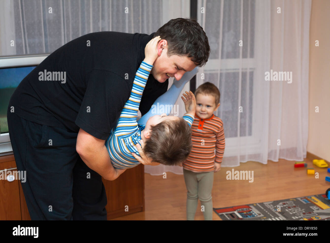 Heureux père jouant avec son enfant garçon à la maison Banque D'Images