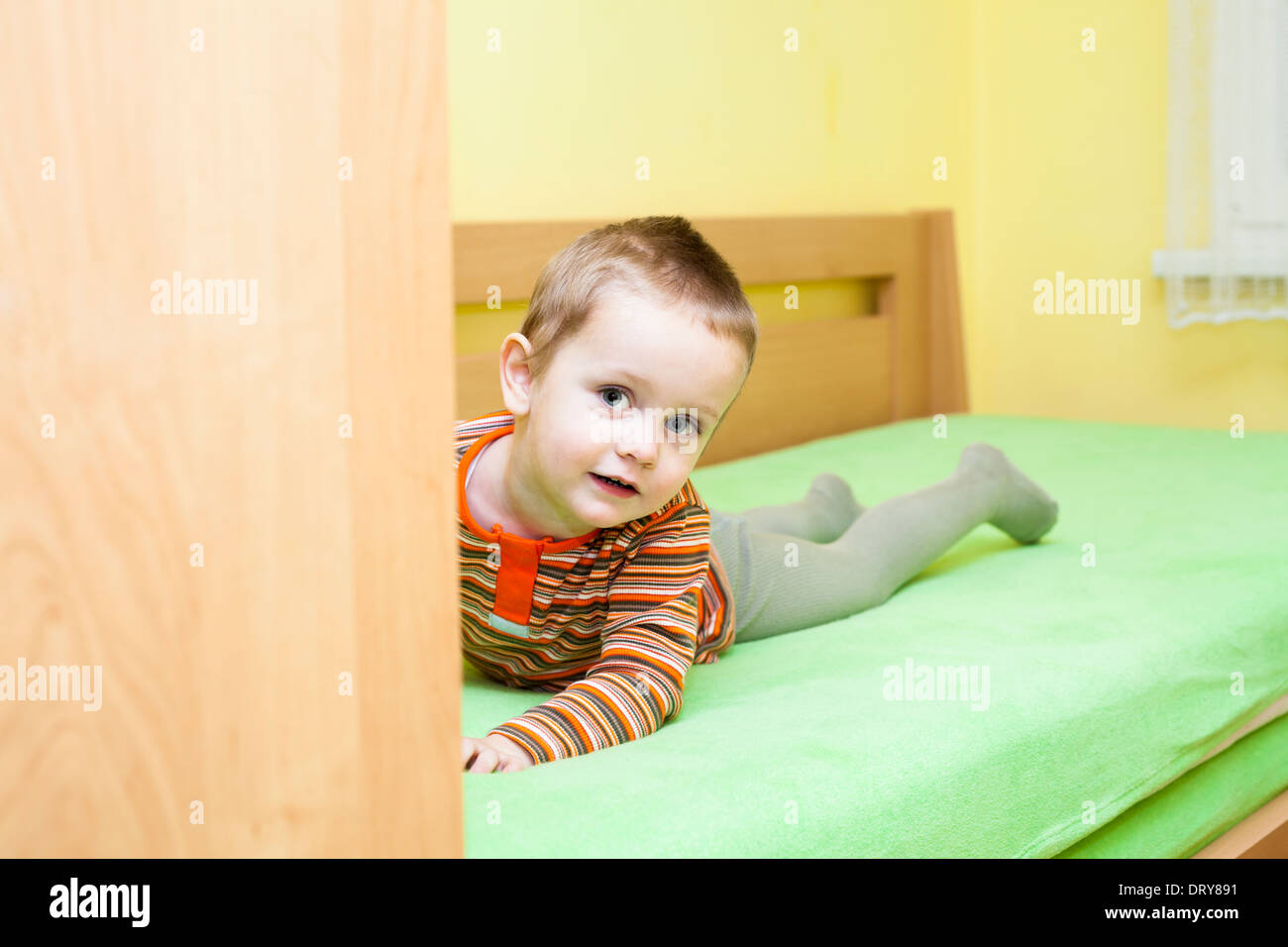Cute child boy lying on bed at home Banque D'Images