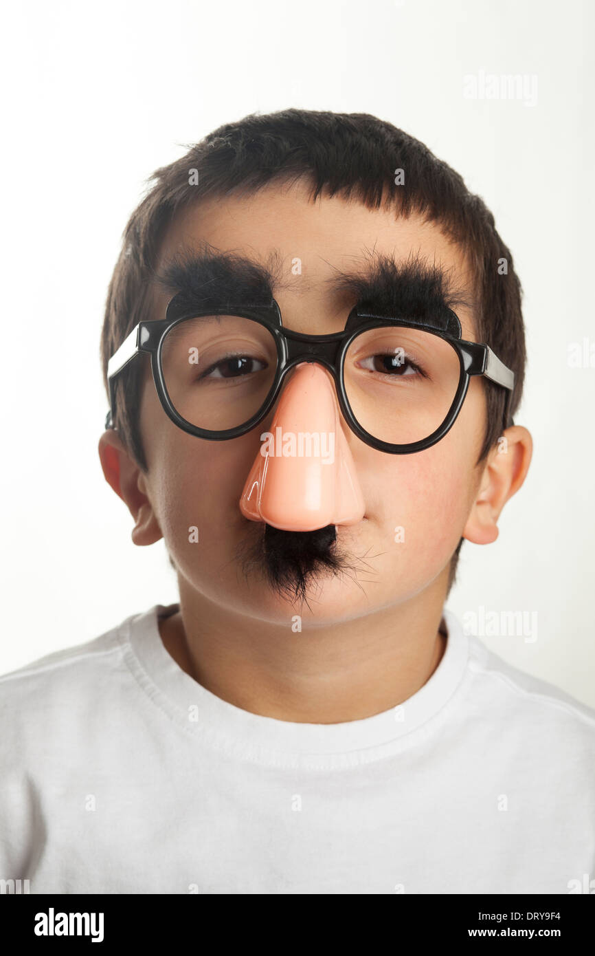 Portrait of boy (7-8) wearing fake lunettes et un fake moustache,studio shot Banque D'Images
