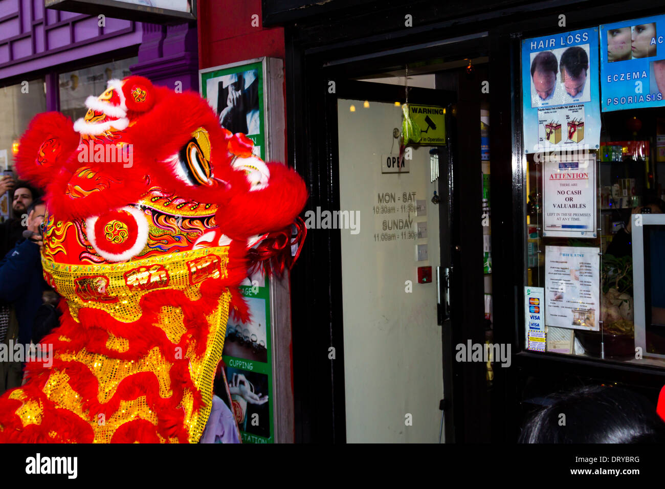 LONDON, UK, 2e mai 2014. Un dragon de manger un chou faim q sur un magasin porte comme partie de la fête du Nouvel An chinois Banque D'Images