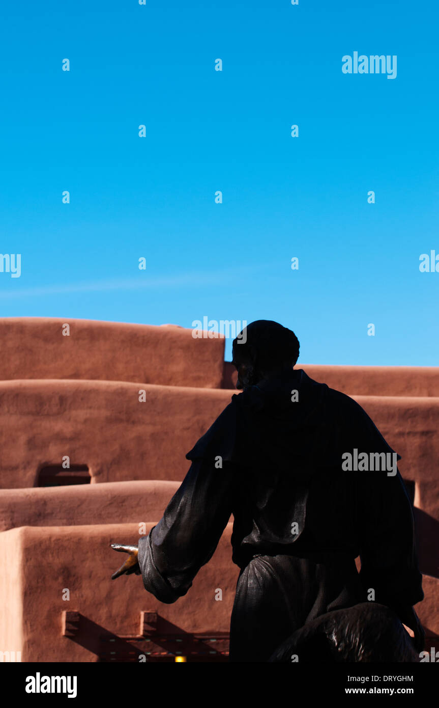 Statue de Saint François, par derrière, qui se trouve en face de la Basilique Cathédrale de Saint François d'assise et de structures d'adobe. Banque D'Images