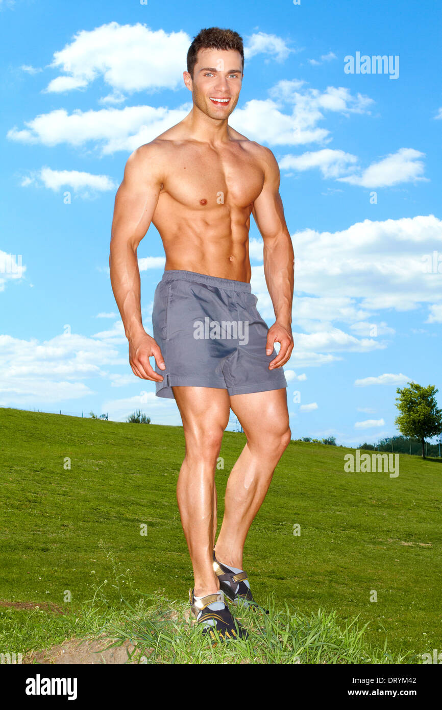 De tout le corps musclé homme debout sur l'herbe Banque D'Images