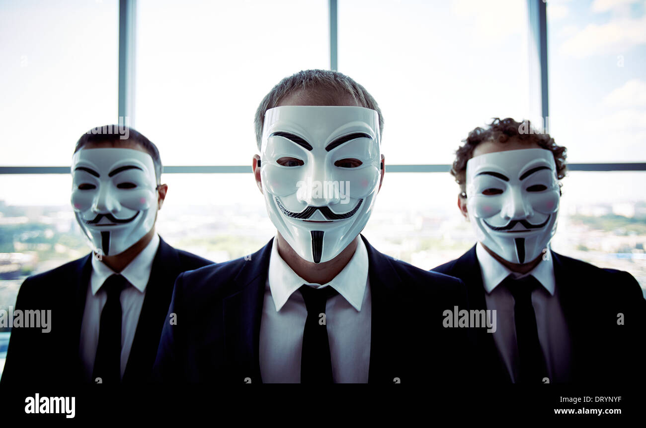 Portrait de trois personnes portant des masques anonymes Banque D'Images