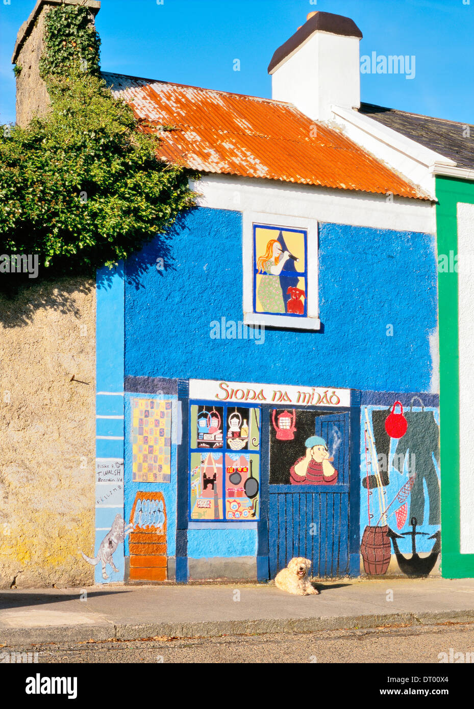 Chien devant de la peinture murale de boutique d'articles de pêche dans village de pêcheurs de Kinvara, sur la rive sud de la baie de Galway, Irlande Banque D'Images