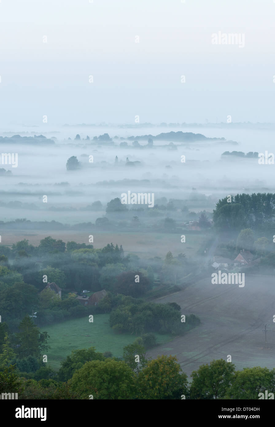 Brume matinale vu de la Wye downs, surplombant le village de Brook avec Ashford dans la distance. Kent, Angleterre. Banque D'Images