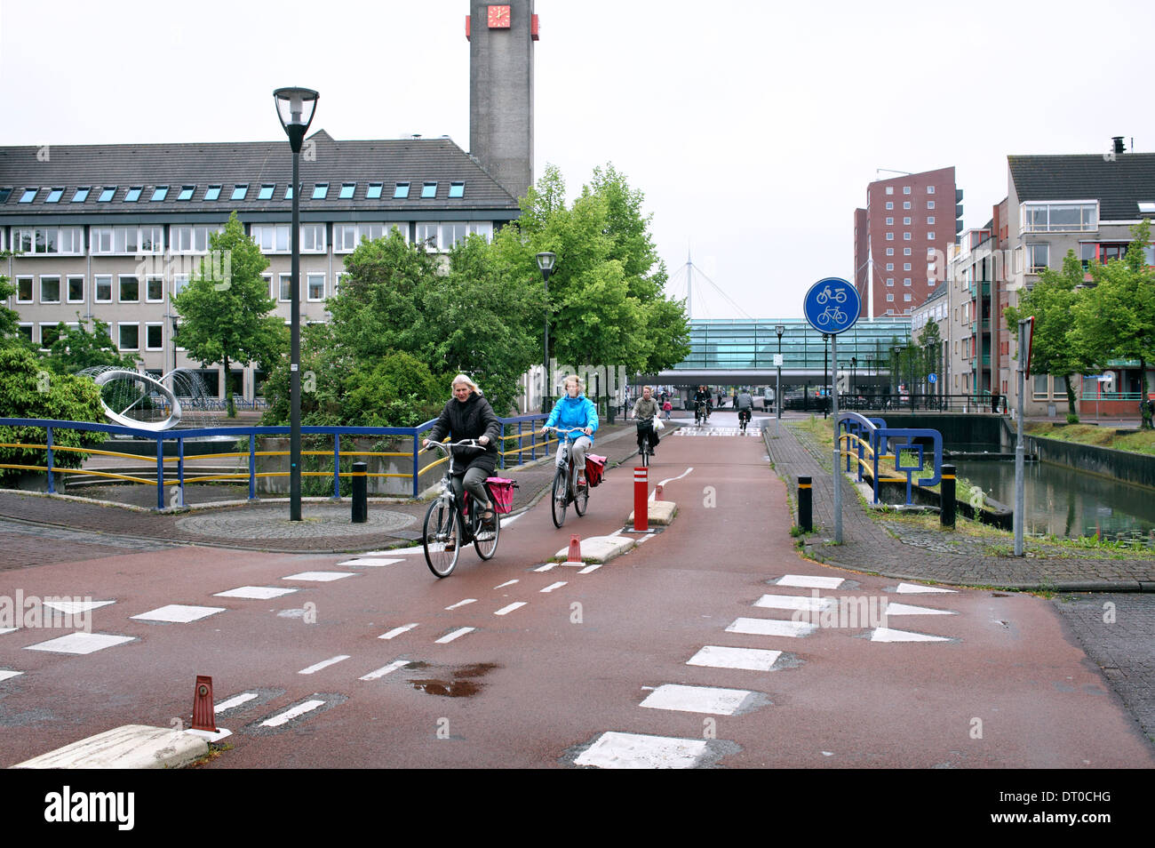 Les cyclistes sur l'un des randonnées à vélo dans la circulation de Houten centre ville (dans l'arrière-plan), une nouvelle ville néerlandaise près d'Utrecht. Banque D'Images