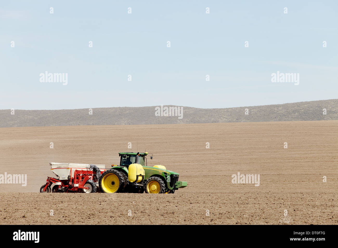 Tracteurs et autres machines agricoles travaillant dans les domaines de la plantation célèbre Pommes de terre Idaho. Banque D'Images