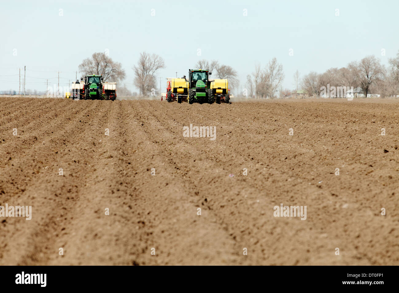 Tracteurs et autres machines agricoles travaillant dans les domaines de la plantation célèbre Pommes de terre Idaho. Banque D'Images