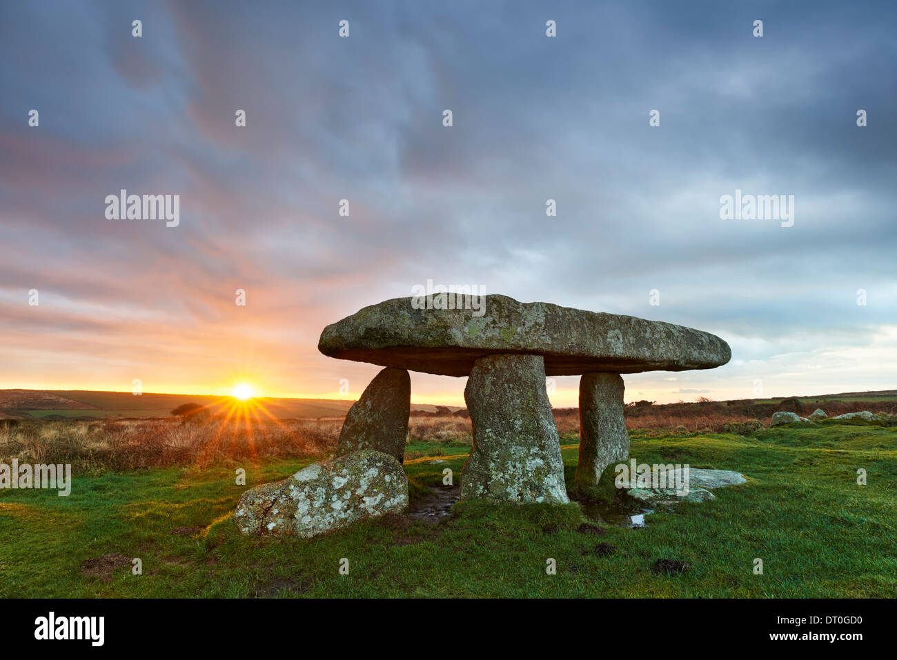 Un bref moment de la lumière du soleil à travers le ciel de traînées aube à Lanyon Quoit Banque D'Images