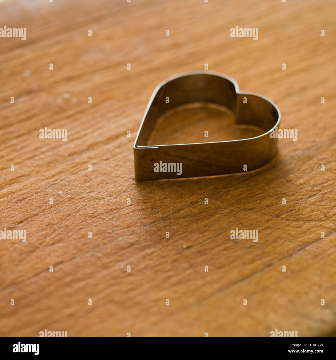 En forme de coeur, métal, coupe-pâte sur une planche de bois. Banque D'Images