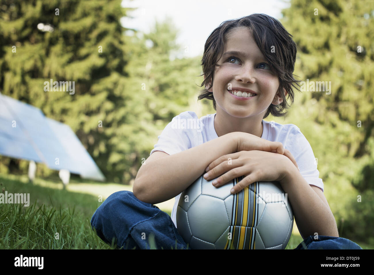 Woodstock, New York USA boy holding football sitting on grass panneau solaire Banque D'Images