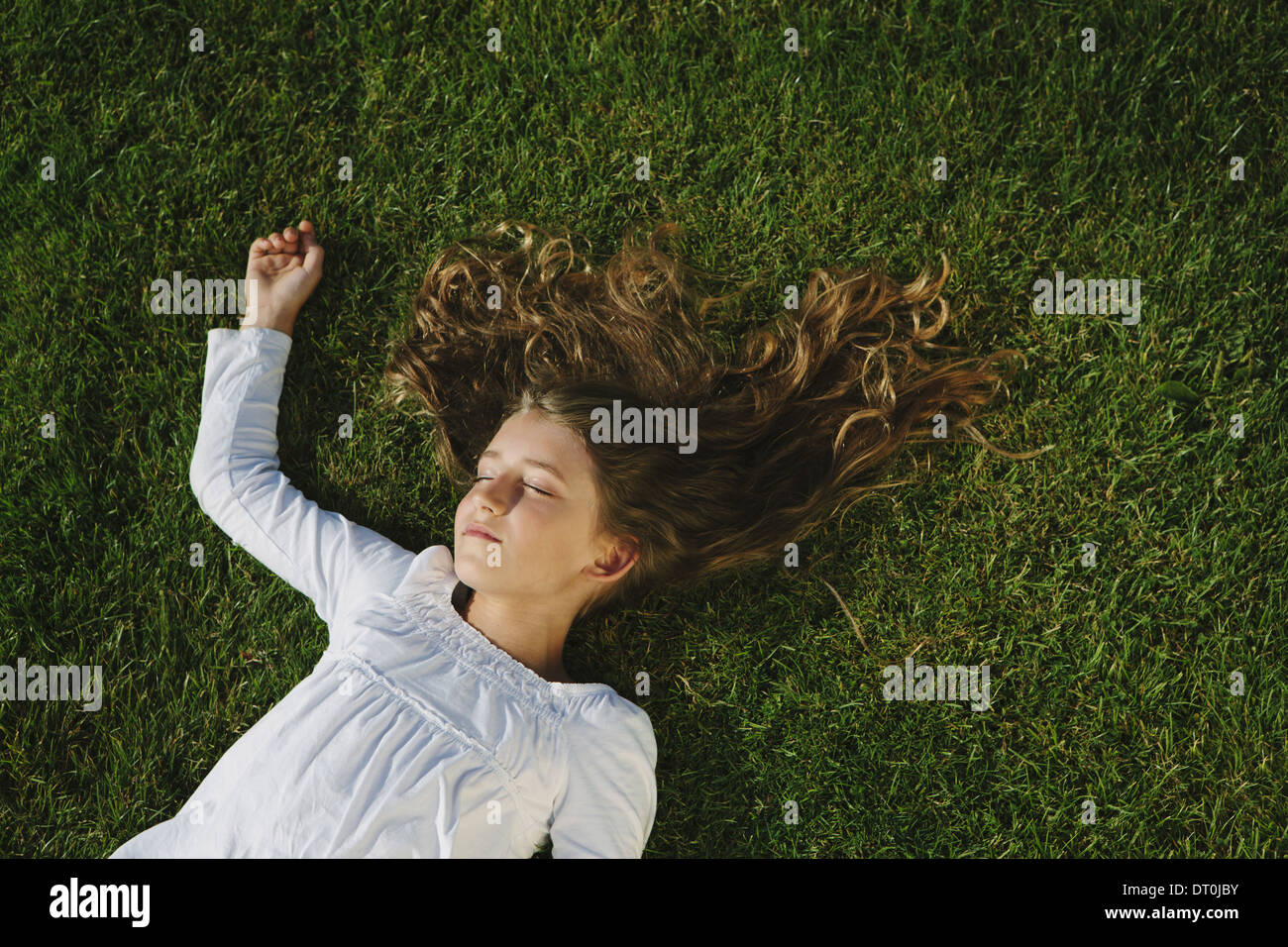 Seattle Washington USA neuf ans, fille, reposant sur l'herbe verte sur le terrain Banque D'Images