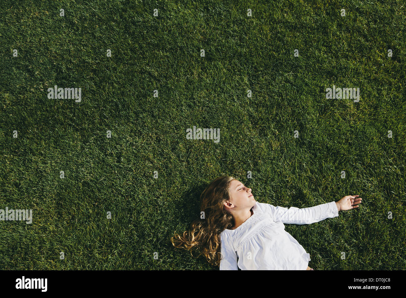 Seattle Washington USA neuf ans, fille, reposant sur l'herbe verte sur le terrain Banque D'Images