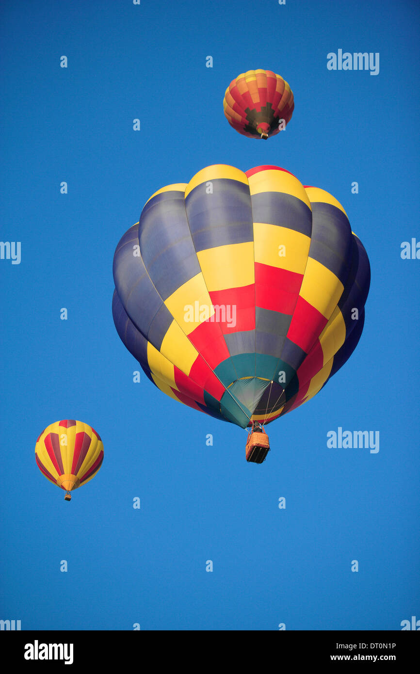 Une vue d'une 3 montgolfières floating against a blue sky Banque D'Images