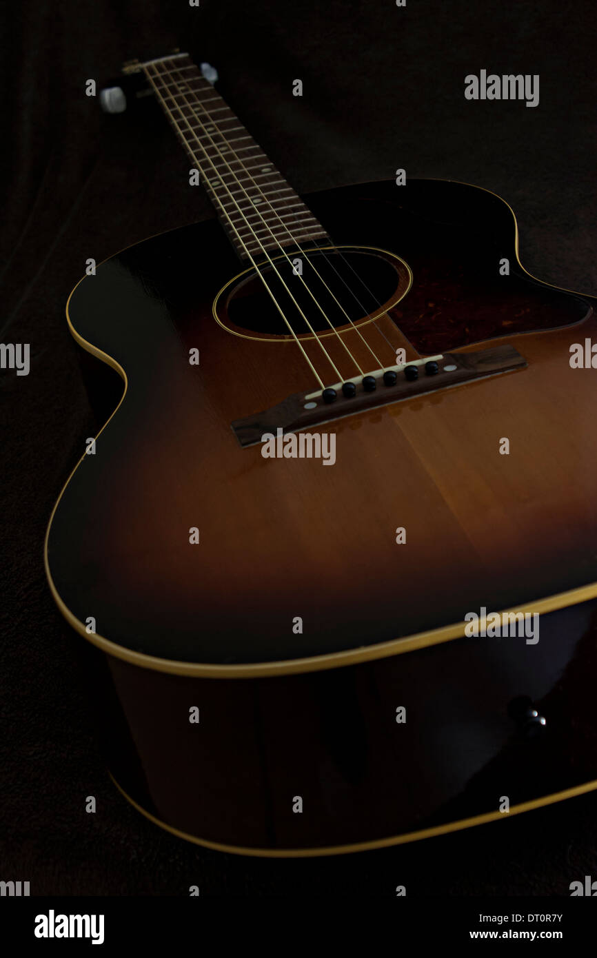 Les courbes magnifiques de cette guitare acoustique avec les couleurs d'auburn et le brun foncé. Banque D'Images