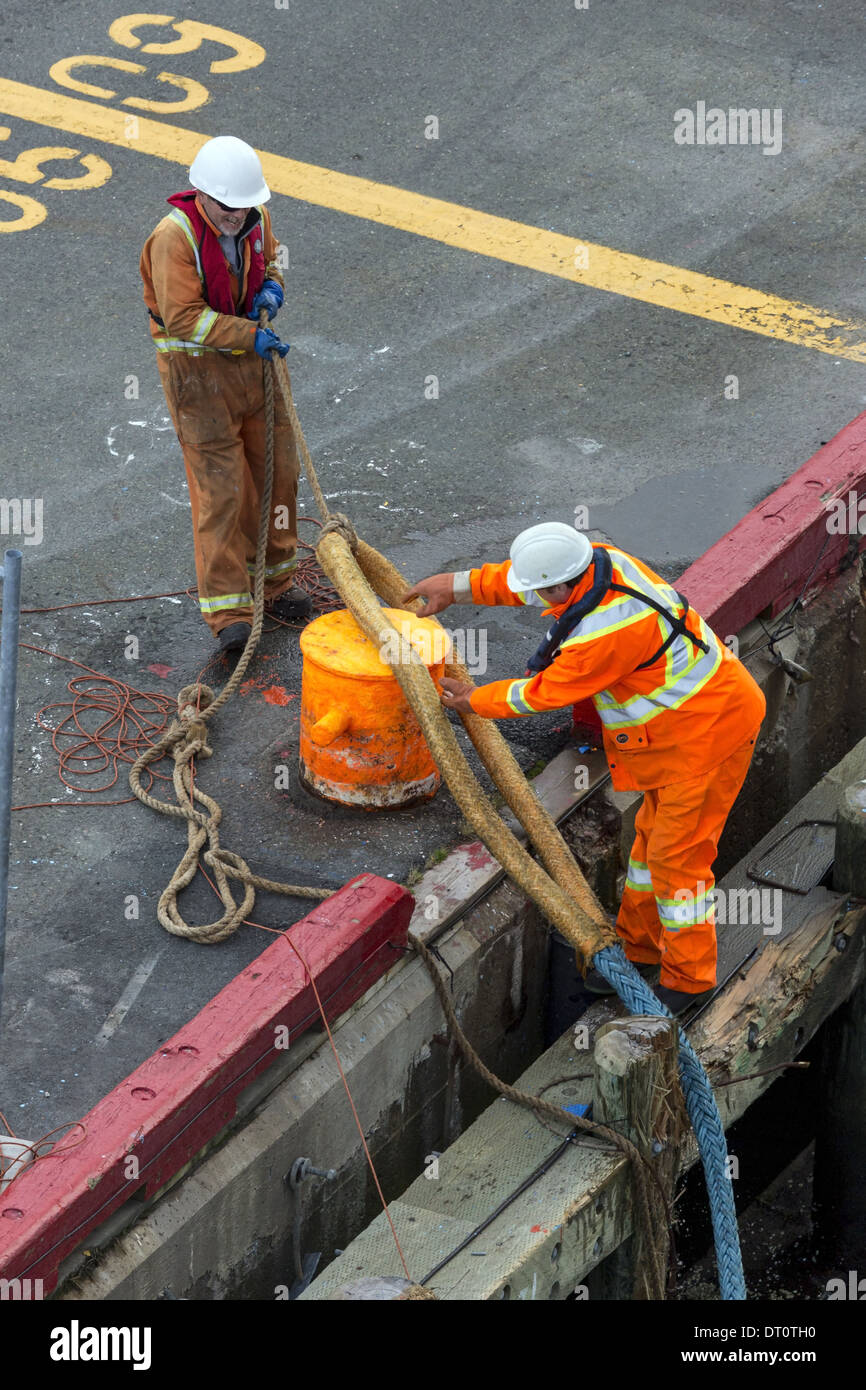 Les hommes qui fixent les hawser cordes pour poteaux sur la vérification à quai Banque D'Images