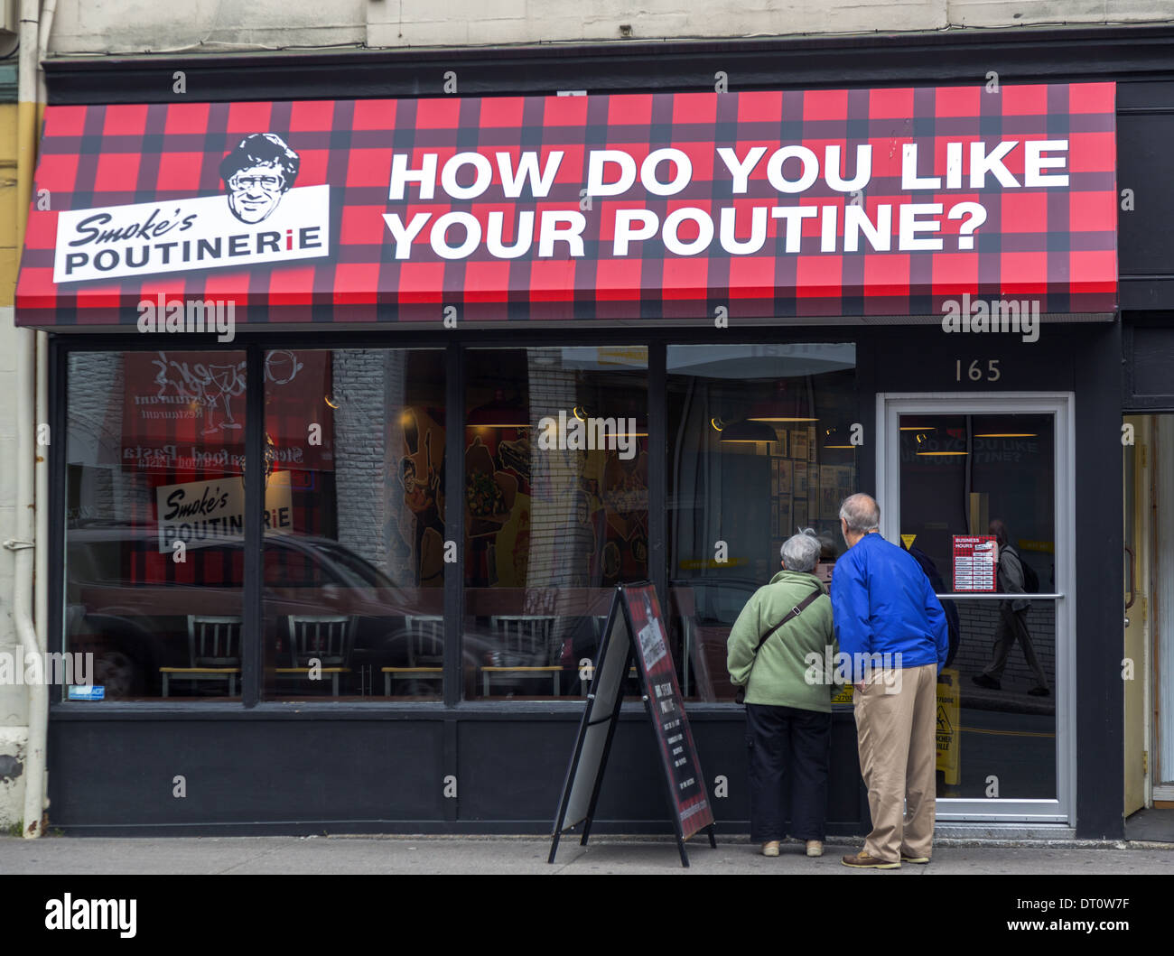 Couple sur le site dans la fenêtre de la fumée Poutine restaurant St. John's Terre-Neuve Canada Banque D'Images