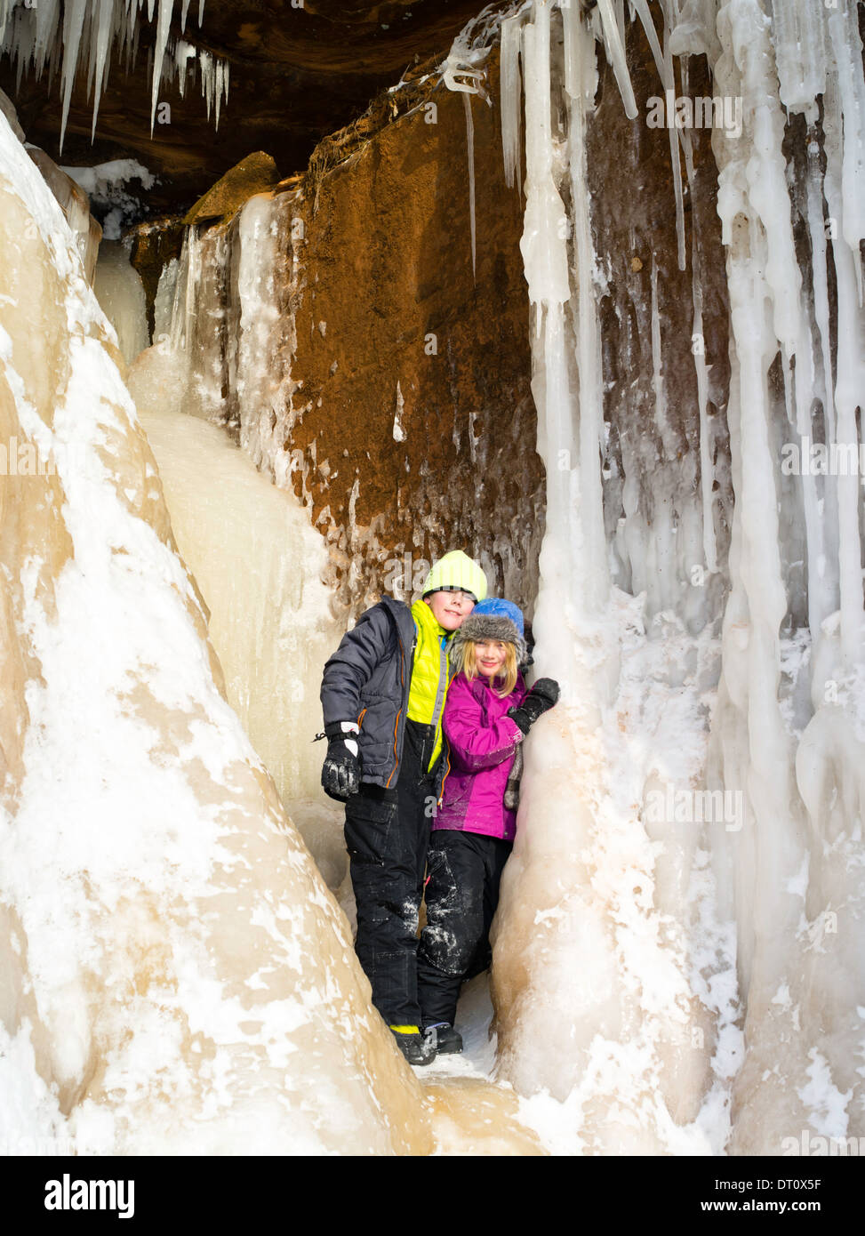 Un frère et une sœur se tenir dans une petite caverne de glace à l'Apôtre Island grottes de glace, Makwike Bay, près de Bayfield, Wisconsin, lors d'une froide Banque D'Images