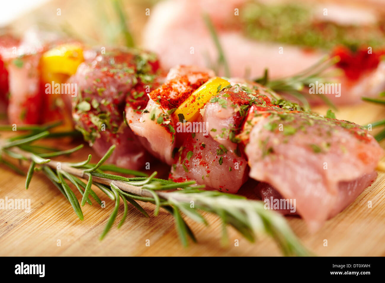 Libre de cracher avec viande de porc épicé et poivre rouge et jaune sur une planche en bois, selective focus Banque D'Images