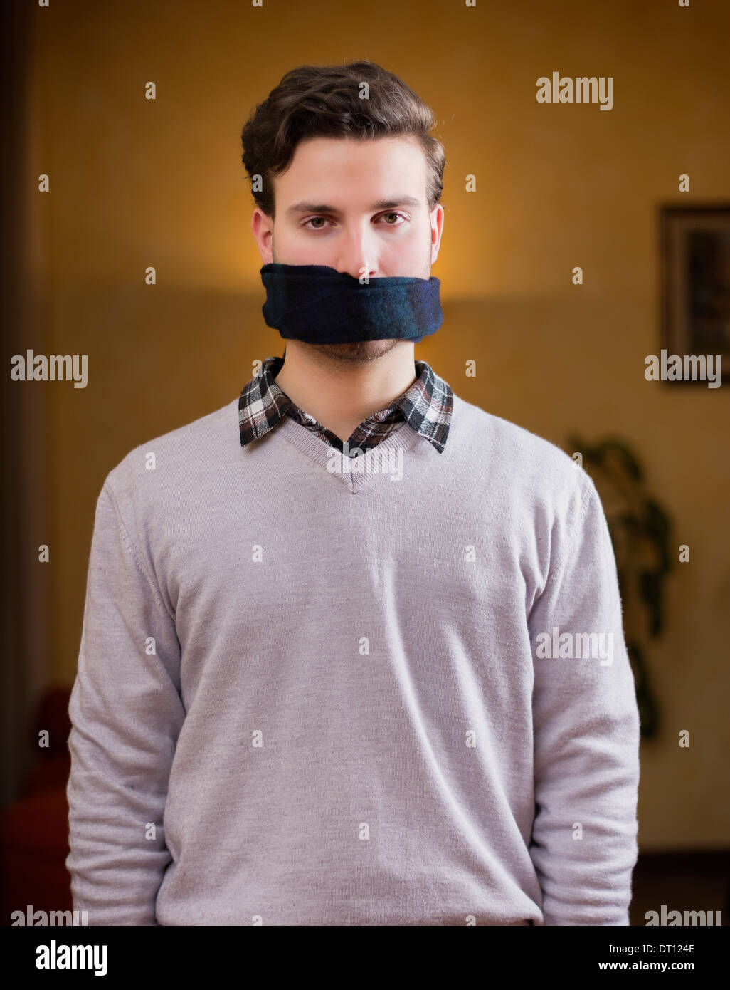 Jeune homme à l'écharpe (GAG) sur sa bouche ne peut pas parler Photo Stock  - Alamy