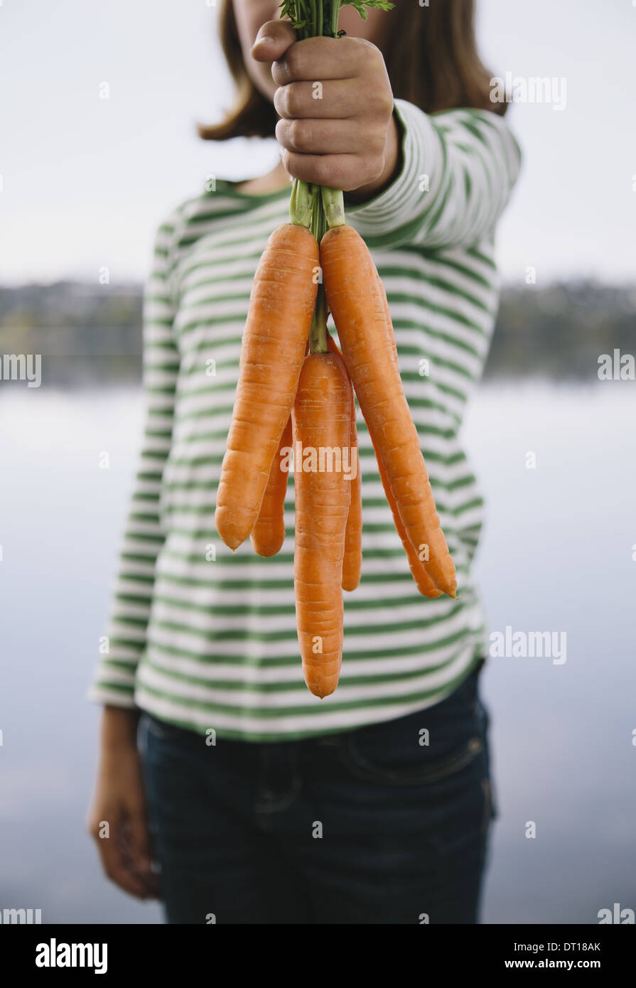 Seattle Washington USA neuf ans girl holding organic carrots Banque D'Images