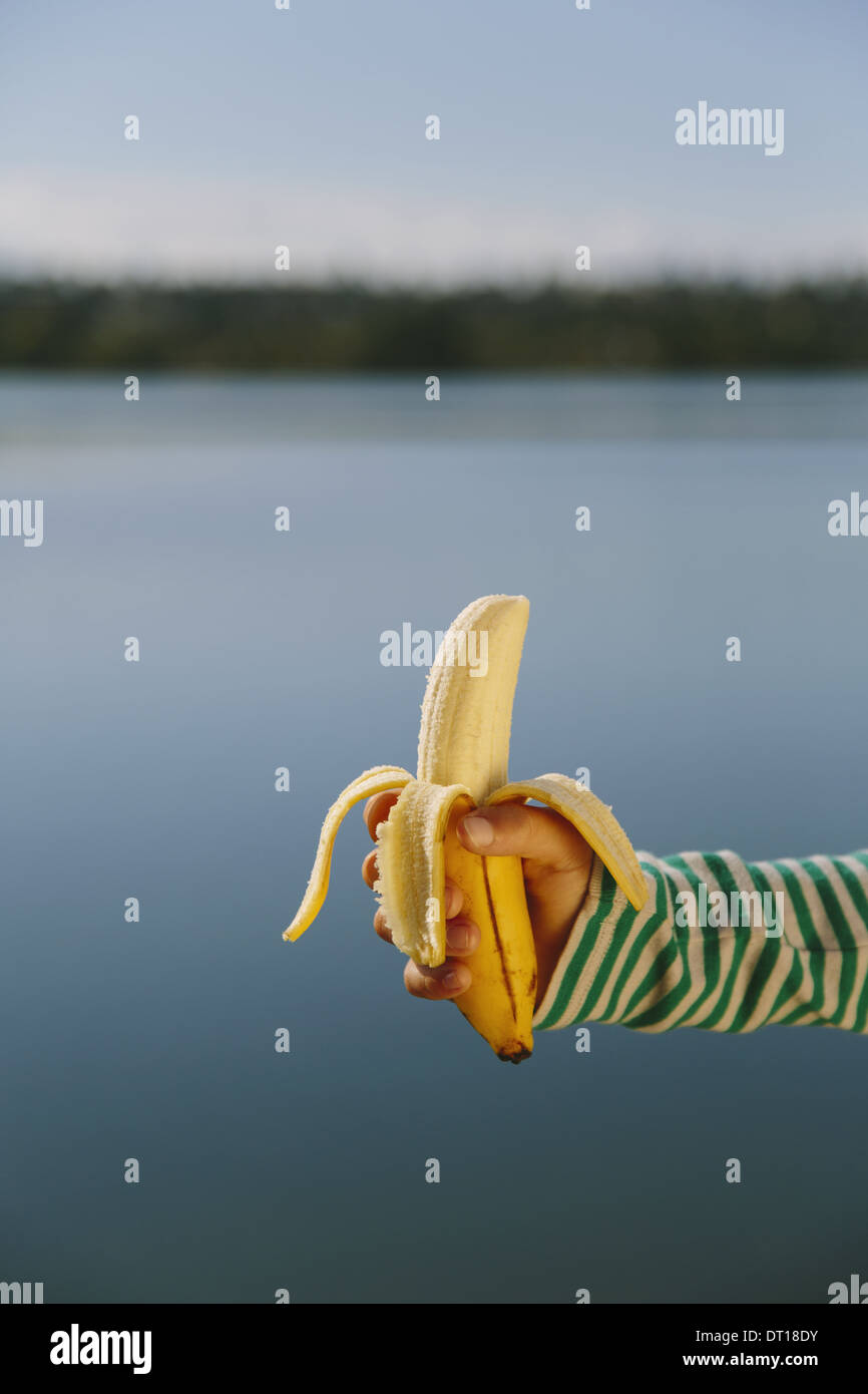 Seattle Washington USA neuf ans, fille biologique de bananes épluchées holding Banque D'Images