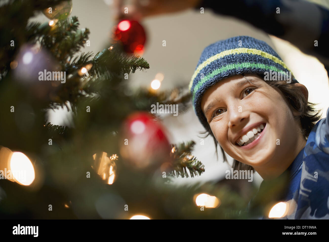 Woodstock, New York USA garçon placer les boules de Noël sur un arbre Banque D'Images