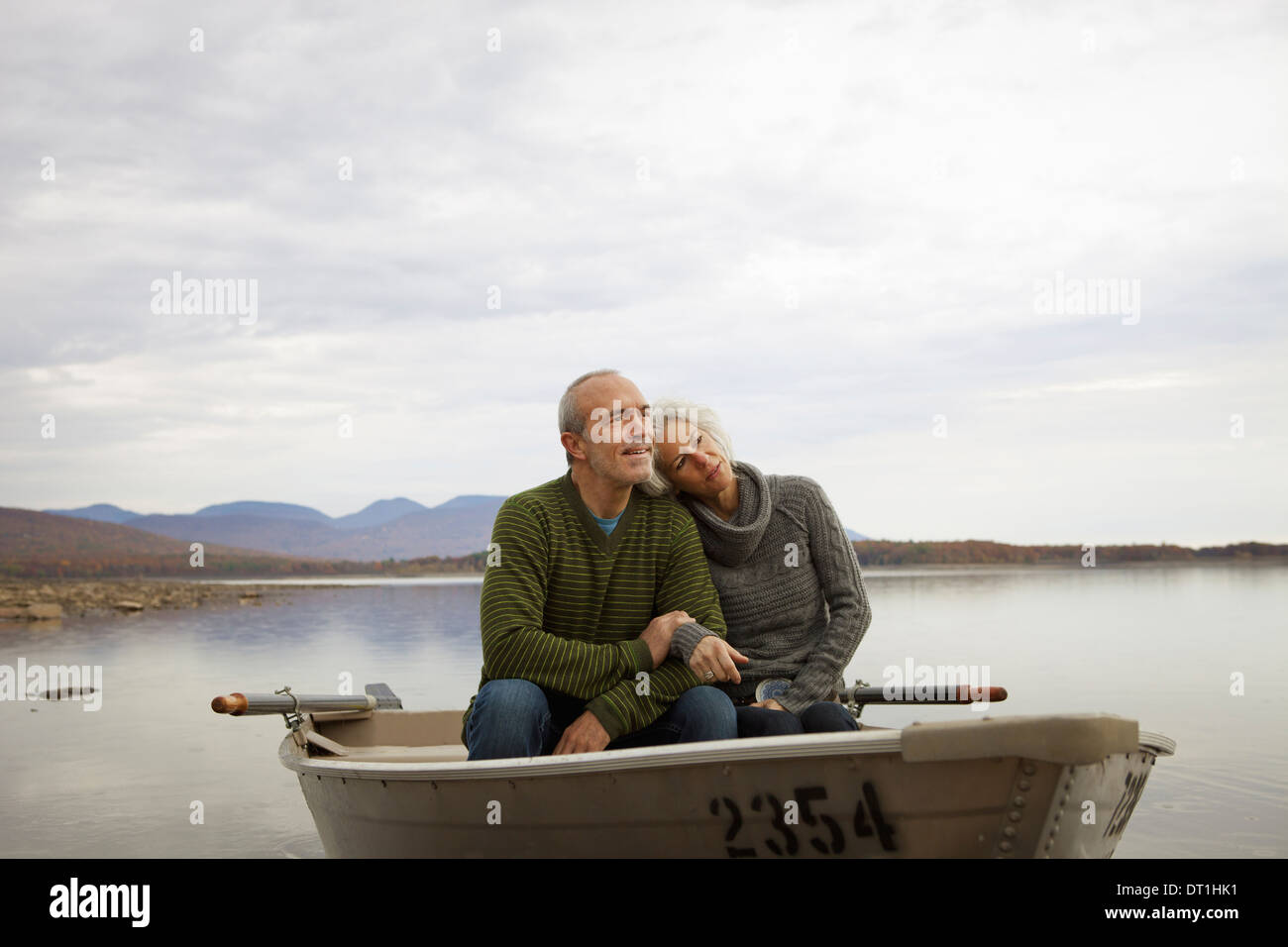 Un couple homme et femme assis dans un bateau à rames sur l'eau une journée d'automne Banque D'Images